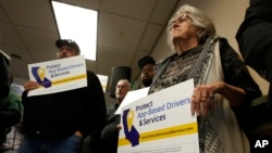 FILE - In this Oct. 29, 2019, file photo, Carla Shrive, right, who drives for various gig into companies, joined other drivers to support a proposed ballot initiative challenging a recently signed law that makes it harder for companies to label…