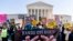 FILE-Stephen Parlato of Boulder, Colo., holds a sign that reads 'Hands Off Roe!!!' as abortion rights advocates and anti-abortion protesters demonstrate in front of the U.S. Supreme Court, Dec. 1, 2021, in Washington. 