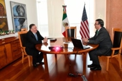 In this handout photo released by the Mexican Government Press Office, U.S. Secretary of State Mike Pompeo and his Mexican counterpart Marcelo Ebrard meet in Mexico City, Sunday morning, July 21, 2019.