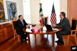 In this handout photo released by the Mexican Government Press Office, U.S. Secretary of State Mike Pompeo and his Mexican counterpart Marcelo Ebrard meet in Mexico City, Sunday morning, July 21, 2019.