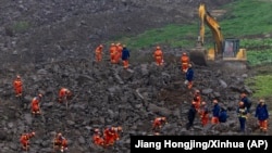 In this photo released by Xinhua News Agency, rescuers search for victims in the aftermath of a landslide in Junlian county near the city of Yibin in southwestern China's Sichuan Province, Feb. 9, 2025. 