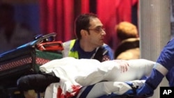 在悉尼劫持人质事件中，急救人员将带有血迹的担架送上救护车。