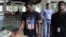 FILE - An Infosys employee sports a t-shirt featuring a U.S. flag as he buys coupons for lunch while others wait for their turn at company headquarters in Bangalore, India, April 15, 2016. 