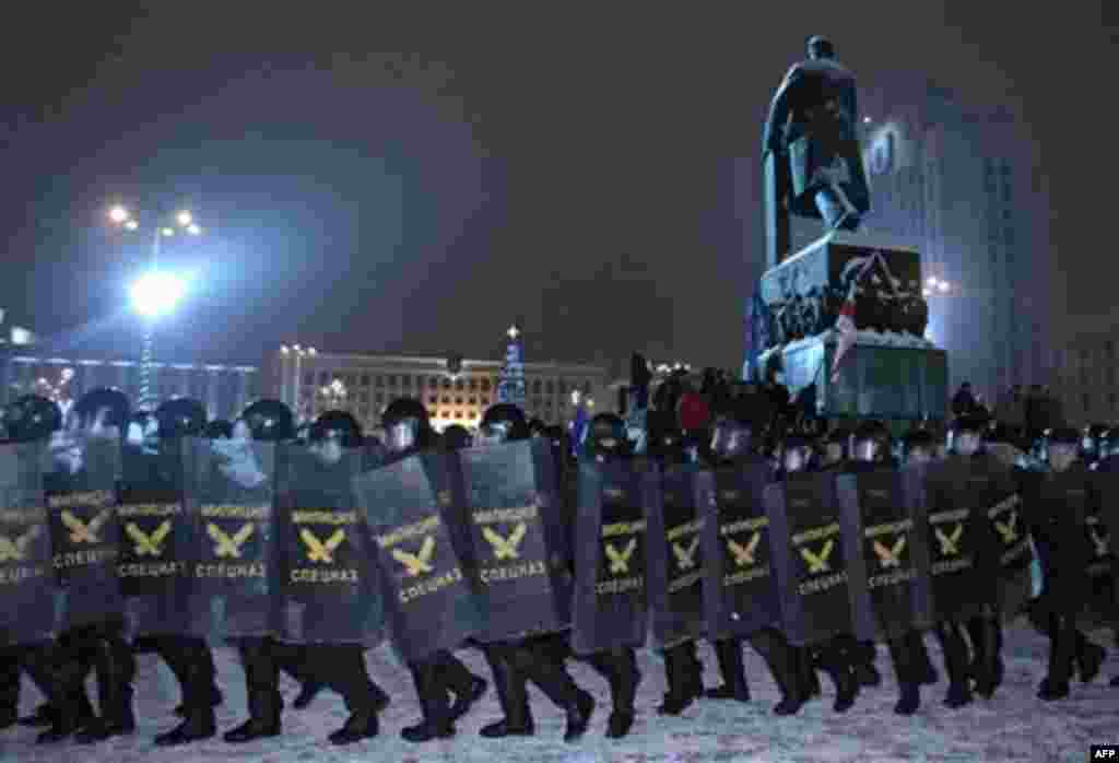 Riot police officers move to form a line to block the road near the government building during a rally in Minsk, Belarus, early Monday, Dec. 20, 2010. Thousands of opposition supporters in Belarus tried to storm the main government building to protest wha