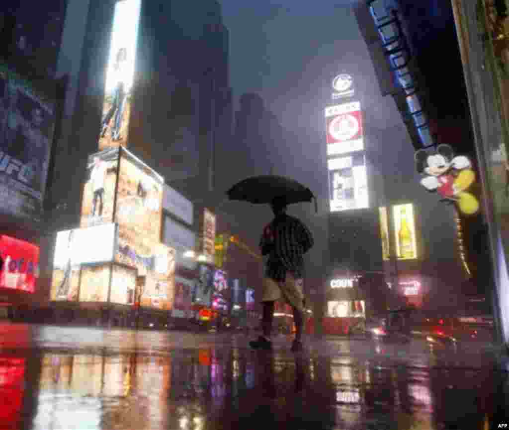 A man walks in Times Square as Hurricane Irene arrives in New York, on Sunday, Aug. 28, 2011. (AP Photo/Mike Groll)