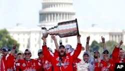 미국 워싱턴 DC의 네셔널몰에서 북미아이스하키리그(NHL) 스탠리컵 우승 축하 기념식이 열린 가운데, 2018년도 우승팀인 워싱턴 캐피털스의 알렉스 오베츠킨이 스탠리컵을 들어 올리고 있다.