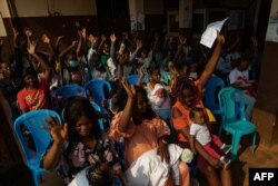 FILE - Mothers with their children listen to a nurse giving advice at a hospital in Soa, Cameroon, on January 22, 2024.