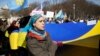 A woman in Washington sings Ukraine's national anthem while holding the national flag during a 2014 protest against Russia's aggression in Ukraine.