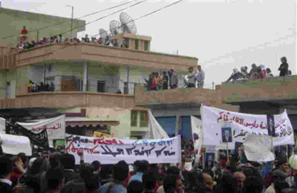 In this citizen journalism image made on a mobile phone, Syrian protesters carry banners in Arabic and Kurdish that call for a democratic nation as they demonstrate in the northeastern town of Qamishli, Syria, April 29, 2011