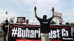Protesters carry placards and banners during a Democracy Day rally in Abuja, Nigeria, June 12, 2021. 