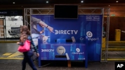 Una mujer pasa frente a una tienda de DirecTV en el centro comercial San Ignacio en Caracas, Venezuela. Enero 10, 2020.