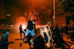 Demonstrators vandalize a car as they protest the death of George Floyd, Sunday, May 31, 2020, near the White House in Washington. Floyd died after being restrained by Minneapolis police officers. (AP Photo/Evan Vucci)