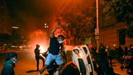 Demonstrators vandalize a car as they protest the death of George Floyd, Sunday, May 31, 2020, near the White House in Washington. Floyd died after being restrained by Minneapolis police officers. (AP Photo/Evan Vucci)