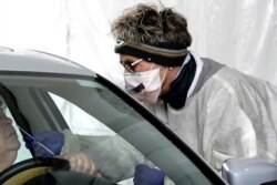 A registered nurse takes a patient's nasal swab at a coronavirus disease drive-thru testing site in Menomonee Falls, Wisconsin, Oct. 18, 2020. (Reuters)