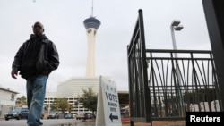 Un hombre pasa por la entrada de un centro de votación en una tarde lluviosa mientras demócratas y republicanos celebran sus elecciones primarias presidenciales en Las Vegas, Nevada, EEUU, el 6 de febrero de 2024