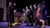 In this photo provided by Peg Shanahan, Lowell District Court Judge Stephen Geary, left, swears in new Mayor Sokhary Chau during the Lowell City Council swearing-in ceremony, Monday, Jan. 3, 2022, in Lowell, Mass., as Chau's family stands with him. (Peg Shanahan via AP)