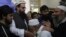 Supporters of Hafiz Saeed, second from left, head of the Pakistani religious party, Jamaat-ud-Dawa, kiss his hands as he arrived at a mosque in Lahore, Pakistan, Nov. 24, 2017. 