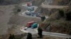 Trucks carry goods on its way to neighboring Afghanistan through the Khyber Pass in Pakistani tribal area, March 21, 2017. A Pakistani border official says hundreds of trucks have crossed into Afghanistan from Pakistan after the border reopened for the fi