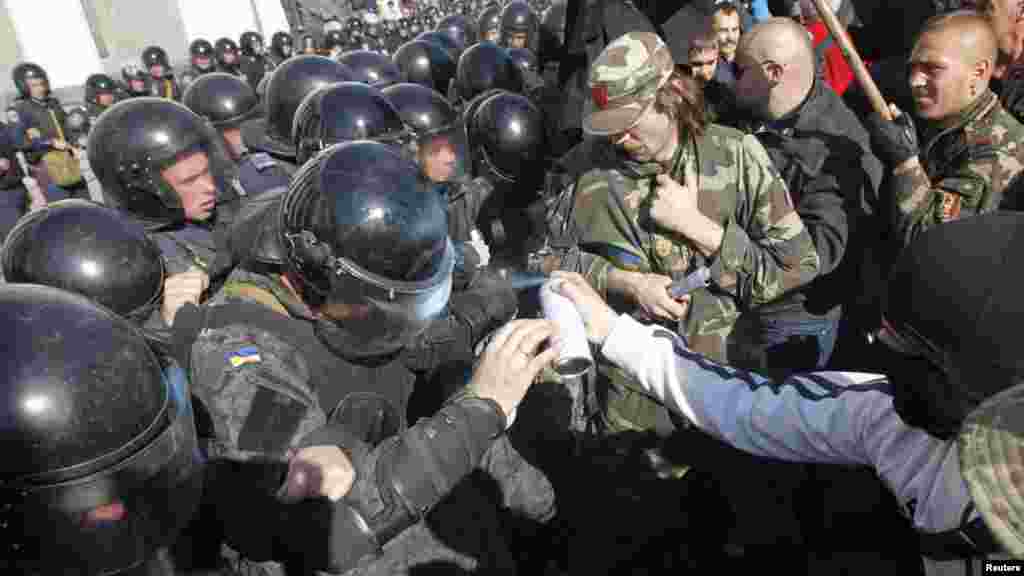 Protesters, right, clash with Interior Ministry and law enforcement members during a rally near the parliament building in Kyiv, Oct. 14, 2014. Thousands of Svoboda nationalist party supporters rallied in Kyiv earlier Tuesday in celebration of the Ukrainian Insurgent Army, but officials from the party denied vehemently that its members were involved in the unrest. 