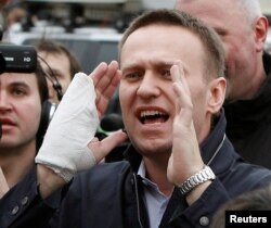 FILE: Pemimpin oposisi Rusia dan blogger anti-korupsi Alexey Navalny (tengah) berbicara kepada wartawan setelah sidang pengadilan di kota Kirov, 17 April 2013. (REUTERS/Maxim Shemetov)