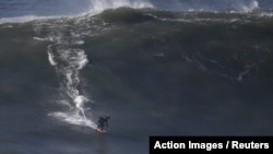 FILE - Brazilian surfer Maya Gabeira drops in on a large wave at Praia do Norte in Nazare, Portugal, Nov. 29, 2015. 