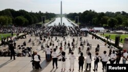 Para anggota keluarga dan kerabat korban kekerasan polisi berdiri di tangga Lincoln Memorial, Washington, D.C., dalam acara "March on Washington" bertajuk, "Lepaskan Lutut Anda dari Kami" 28 Agustus 2020. (REUTERS/Jonathan Ernst/Pool)