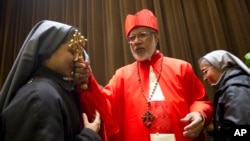 The then-elected cardinal George Alencherry, of India, center, is greeted by nuns after being elevated in St. Peter's Basilica at the Vatican, Feb. 18, 2012. 