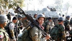 Cambodian soldiers carry their weapons near Preah Vihear temple along the border with Thailand, February 6, 2011