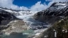 FILE - A lake of meltwater has formed on the tongue of the Rhone Glacier near Goms, Switzerland, June 13, 2023.