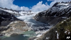 FILE - A lake of meltwater has formed on the tongue of the Rhone Glacier near Goms, Switzerland, June 13, 2023.