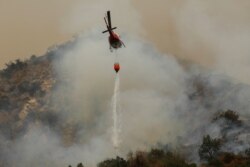 13일 미국 캘리포니아주 아카디아에서 소방헬기가 산불을 끄기 위해 물을 뿌리고 있다.