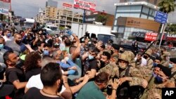 Anti-government protesters scuffle with Lebanese army soldiers in the town of Zouk Mosbeh, north of Beirut, Lebanon, April 27, 2020. 