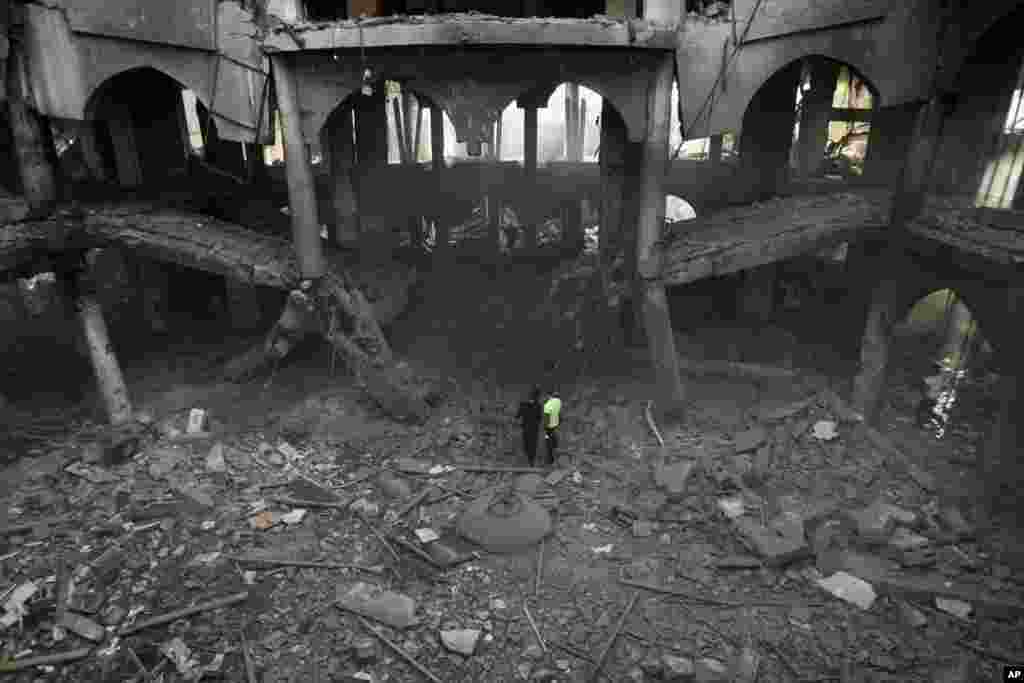 FILE - Palestinians inspect the damage of a Rafah commercial center after an Israeli strike in Rafah, in the southern Gaza Strip, Sunday, Aug. 24, 2014. 