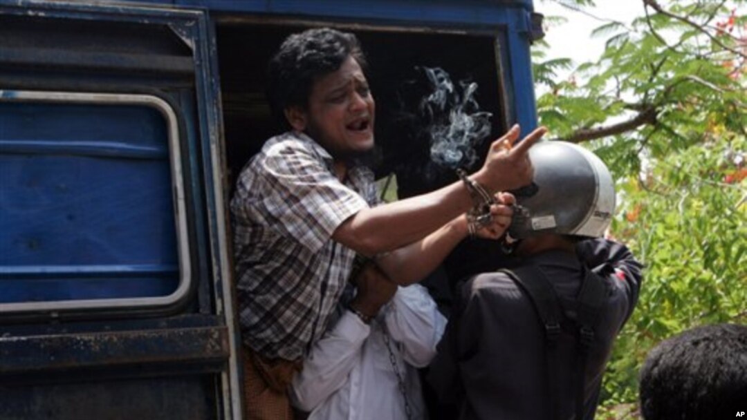 Salah seorang dari tujuh pria yang ditangkap atas tuduhan pembunuhan seorang biksu, berteriak dari kendaraan yang membawanya ke pengadilan di Meikhtila, Burma (21/5). 