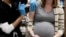 FILE - A pregnant woman receives a vaccine for the coronavirus disease (COVID-19) at Skippack Pharmacy in Schwenksville, Pennsylvania, Feb. 11, 2021.