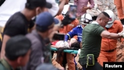 A rescue team carries a wounded worker at a collapsed building in Sihanoukville, Cambodia, June 22, 2019. 
