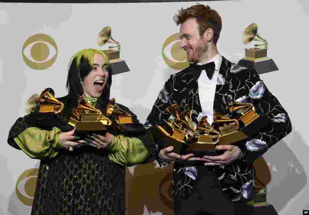 Billie Eilish, left, and Finneas O&#39;Connell pose in the press room with the awards for best album, best engineered album and best pop vocal album for &quot;We All Fall Asleep, Where Do We Go?,&quot; best song and record for &quot;Bad Guy,&quot; best new artist and best producer, non-classical at the 62nd annual Grammy Awards at the Staples Center in Los Angeles, Jan. 26, 2020.