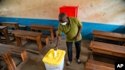 FILE - A man votes in the presidential elections at a polling stating in Brazzaville, Congo, March 21, 2021.