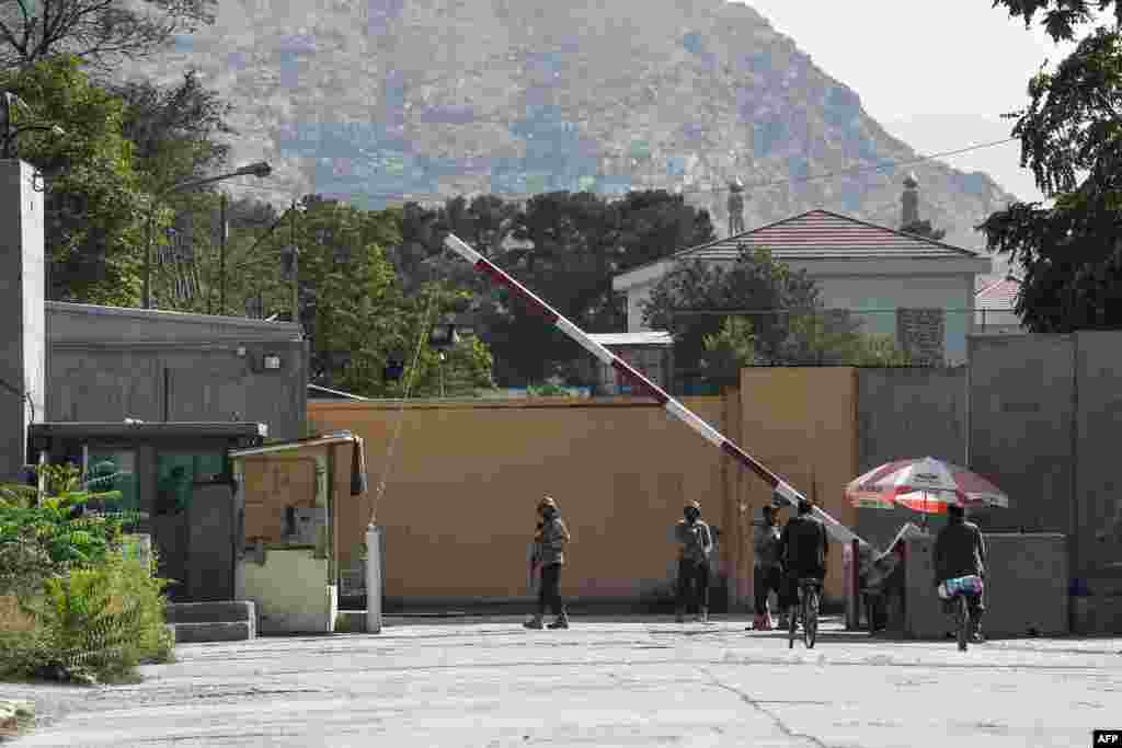 Afghan security personnel stand guard in front of a gate in the Green Zone in Kabul, Aug. 15, 2021.