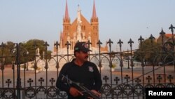 A police officer stands guard outside St. Patrick's Cathedral ahead of the Christmas celebrations in Karachi, Pakistan, Dec. 20, 2017. Many Christians are celebrating Christmas under increased security.