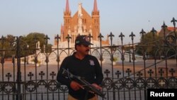 ຕໍາຫລວດຄົນນຶ່ງກໍາລັງຢືນຍາມ ຢູ່ນອກໂບດໃຫຍ່ St. Patrick ໃນນະຄອນຫລວງ ກາຣາຊີ ຂອງປາກິສຖານ ກ່ອນໜ້າການສະຫລອງວັນບຸນຄຣິສ ໃນວັນທີ 20 ທັນວາ, 2017.