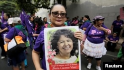 Una mujer sostiene un cartel con una foto de la activista ambiental indígena Berta Cáceres, durante una protesta para conmemorar el Día Internacional de la Mujer frente a la fiscalía en Tegucigalpa, Honduras, el 8 de marzo de 2019.