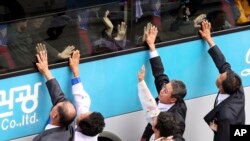 FILE - South Koreans on a bus touch the bus window in their attempt to feel the hands of their North Korean relatives as they bid farewell after the Separated Family Reunion Meeting at Diamond Mountain resort in North Korea.