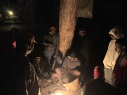 Applicants outside a Harare passport office use fire to keep cold at bay, June 21, 2019. (C. Mavhunga/VOA)