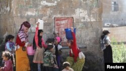 FILE —Girls fill buckets from a water faucet in Bani Matar, Yemen, one of the world's most water-stressed countries, where climate change-induced drought and the lack of sustainable water supplies prevail, August 24, 2023