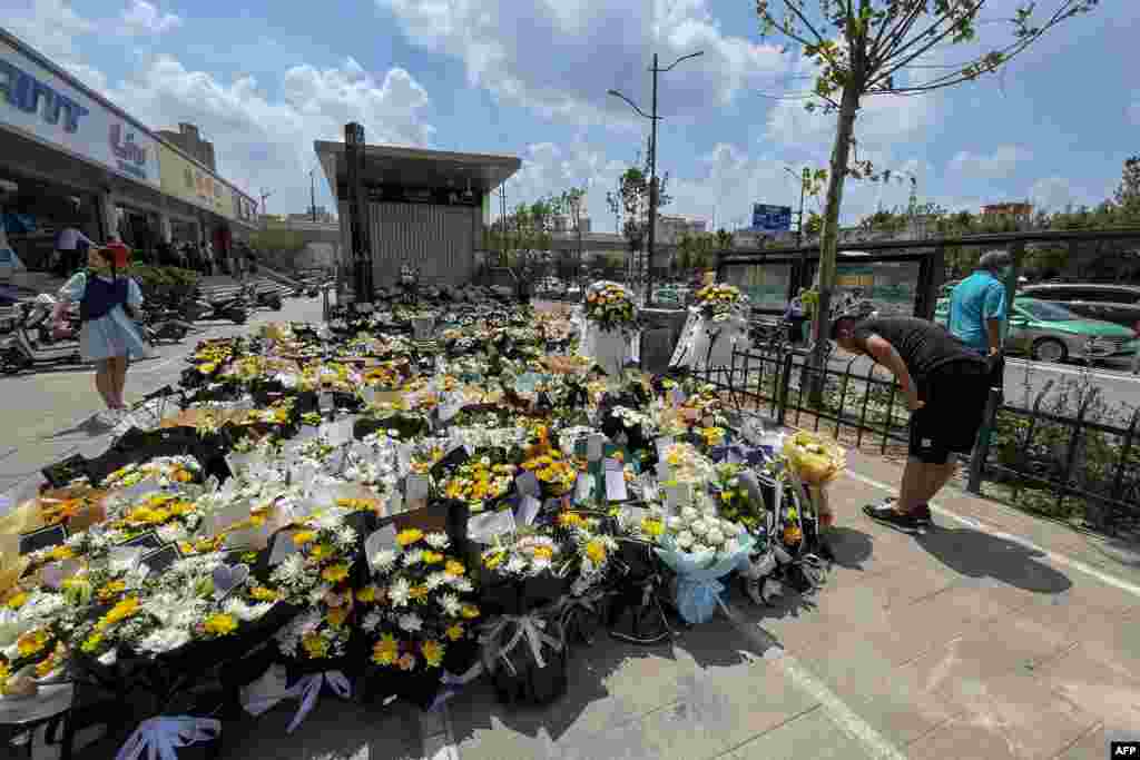 중국 정저우 시민들이 지하철역 입구에 홍수 희생자들을 추모하기 위해 꽃바구니를 놓았다. 