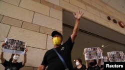Para pendukung aktivis pro-demokrasi Hong Kong berdemo di depan gedung pengadilan West Kowloon Magistrates, saat persidangan para aktivis, di Hong Kong, China, Senin, 31 Mei 2021. (Foto: Reuters)