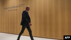 French politician and bodyguard Thierry Légier walks next to a courtroom at a court house on the starting day of a trial on suspicion of embezzlement of European public funds by members of the French far right party, in Paris, Sept. 30, 2024.