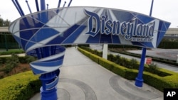 FILE - In this file photo taken Wednesday, March 18, 2020, one of the normally bustling entrances to the Disneyland resort is vacant due to the coronavirus closure in Anaheim, Calif. Disney is postponing the mid-July reopening of its Southern…