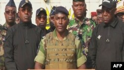 FILE - This video grab taken from a video obtained by AFPTV from Gabon 24 on Aug. 30, 2023 shows Colonel Ulrich Manfoumbi Manfoumbi (C), spokesperson of the Committee for the Transition and Restoration of Institutions (CTRI), reading a statement on television.
